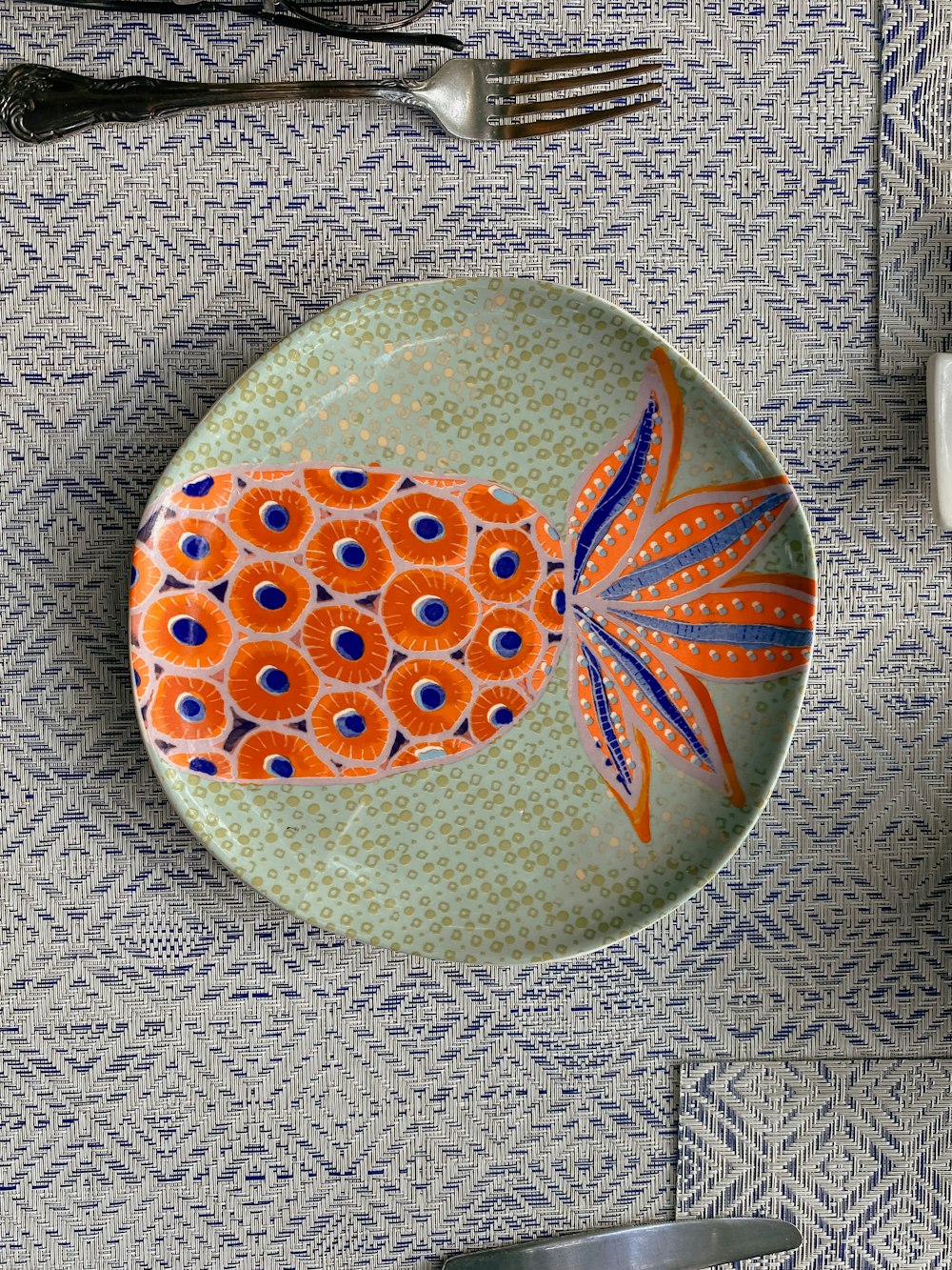 a plate with an orange fish on it