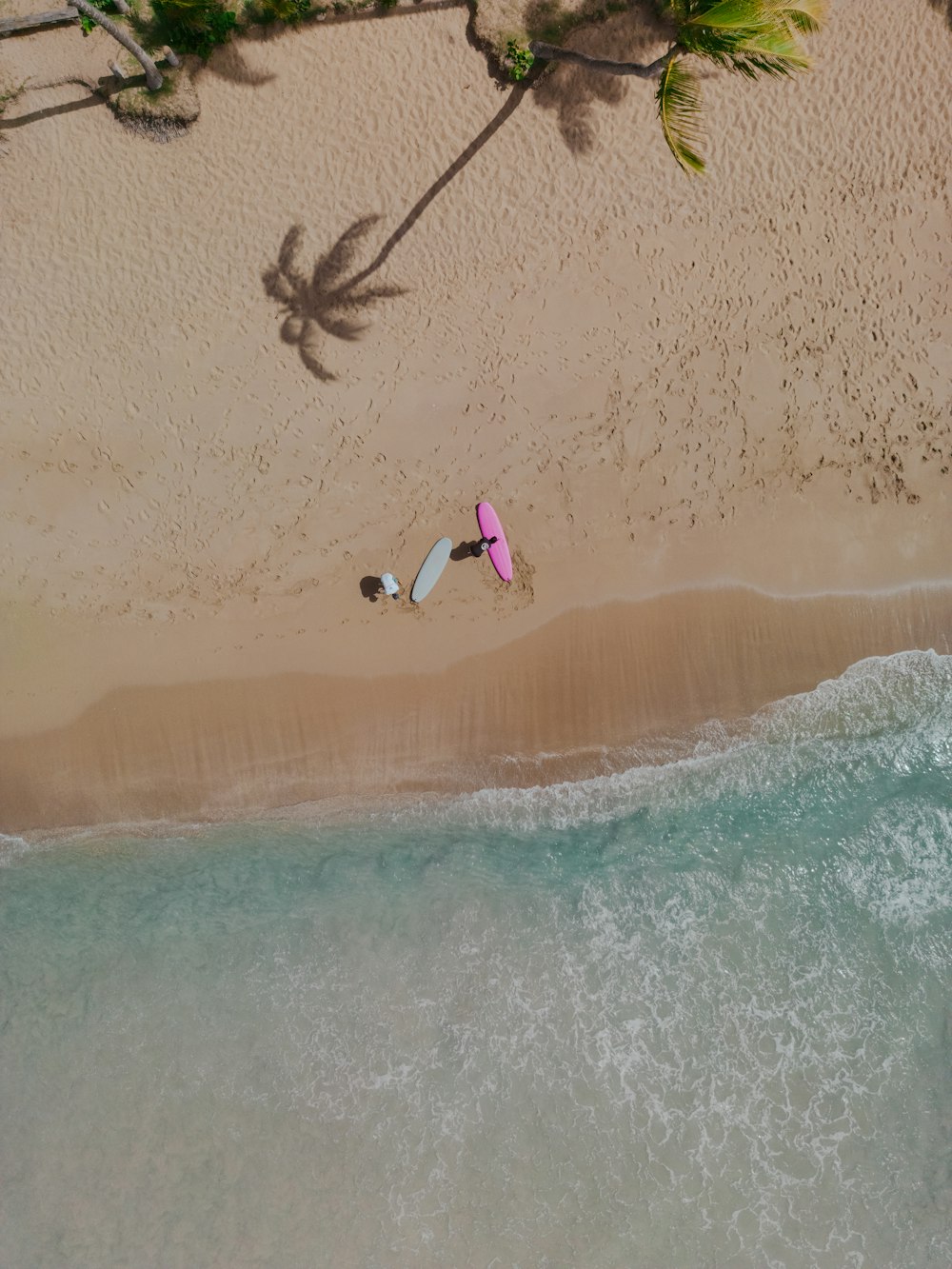 a couple of people laying on top of a sandy beach