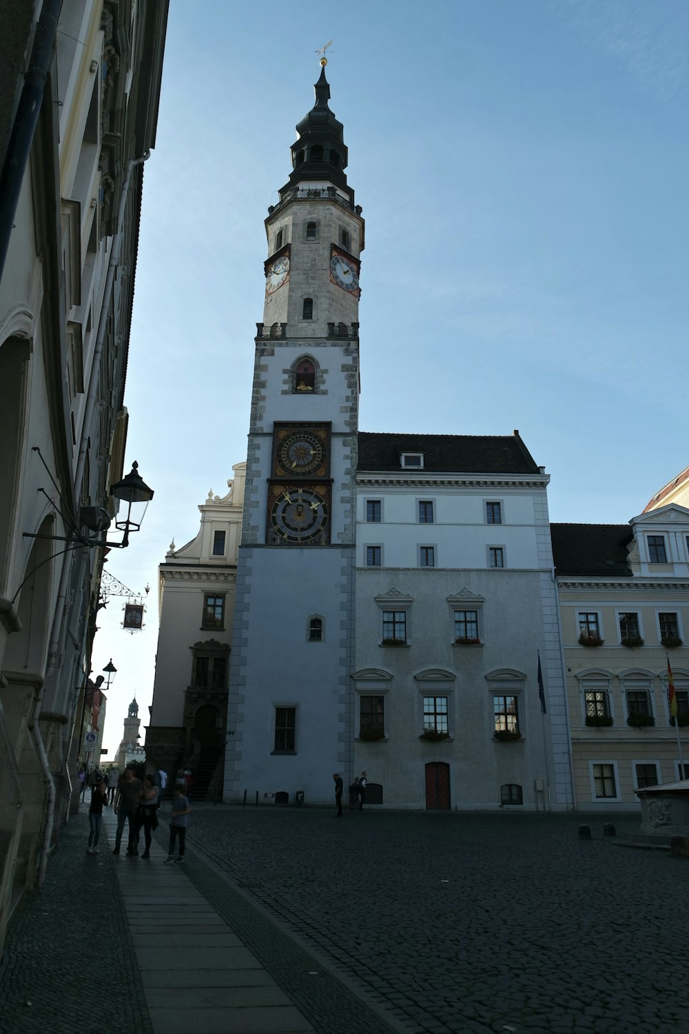 a tall white building with a clock on it's side