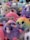 A collection of plush toys with various colors and designs, including unicorns, penguins, and other adorable animals, mostly in pastel and bright hues. The toys are densely packed together, creating a fluffy and vibrant scene.