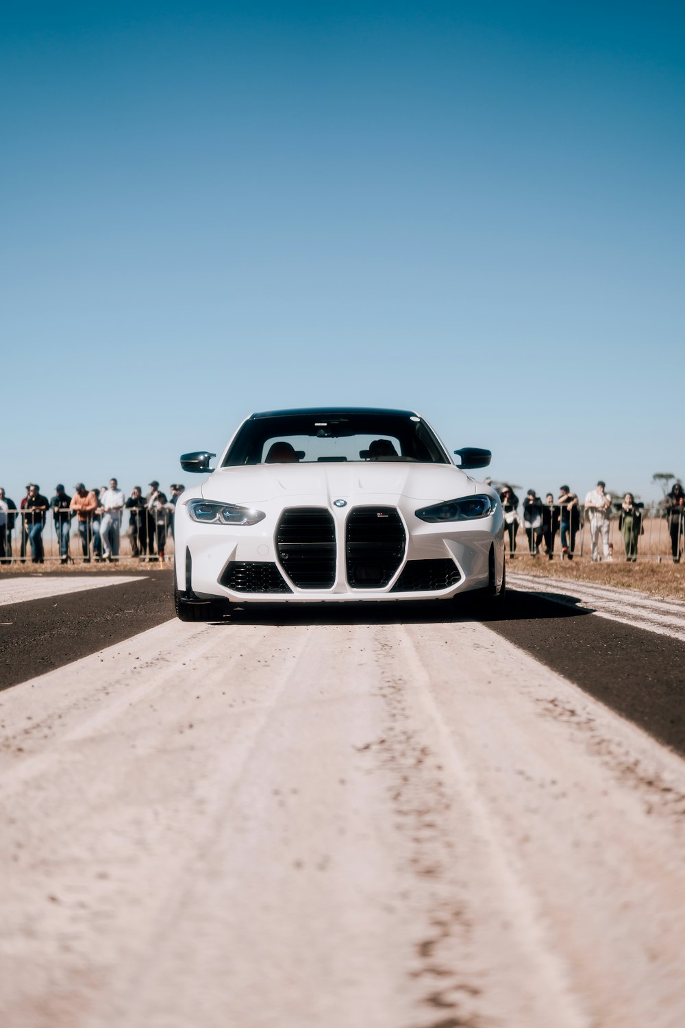 a white car driving down a dirt road