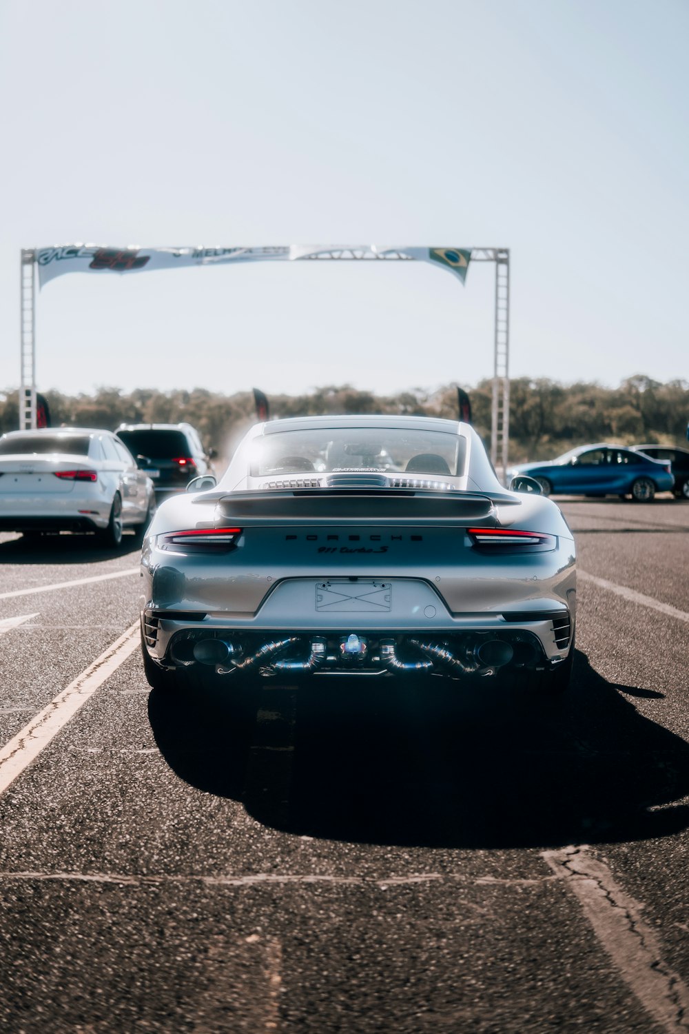 a silver porsche parked in a parking lot