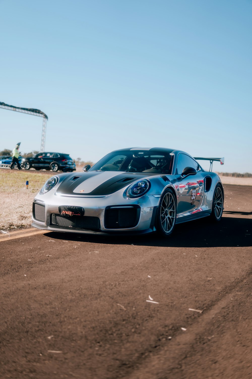 a silver sports car driving down a race track