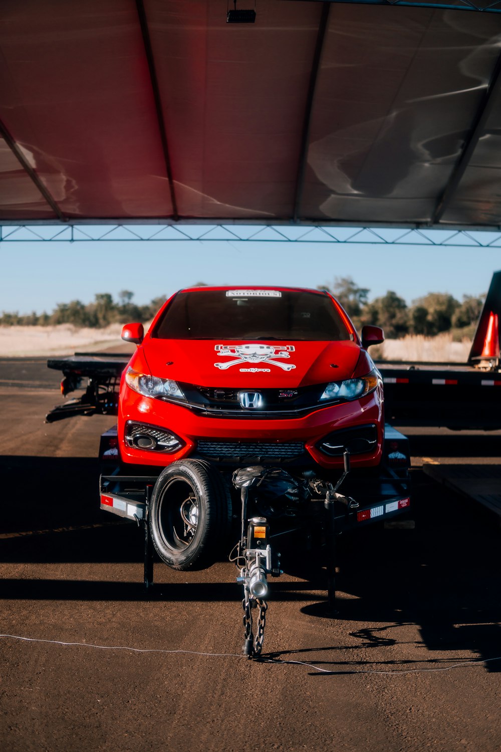 a red car is parked under a canopy