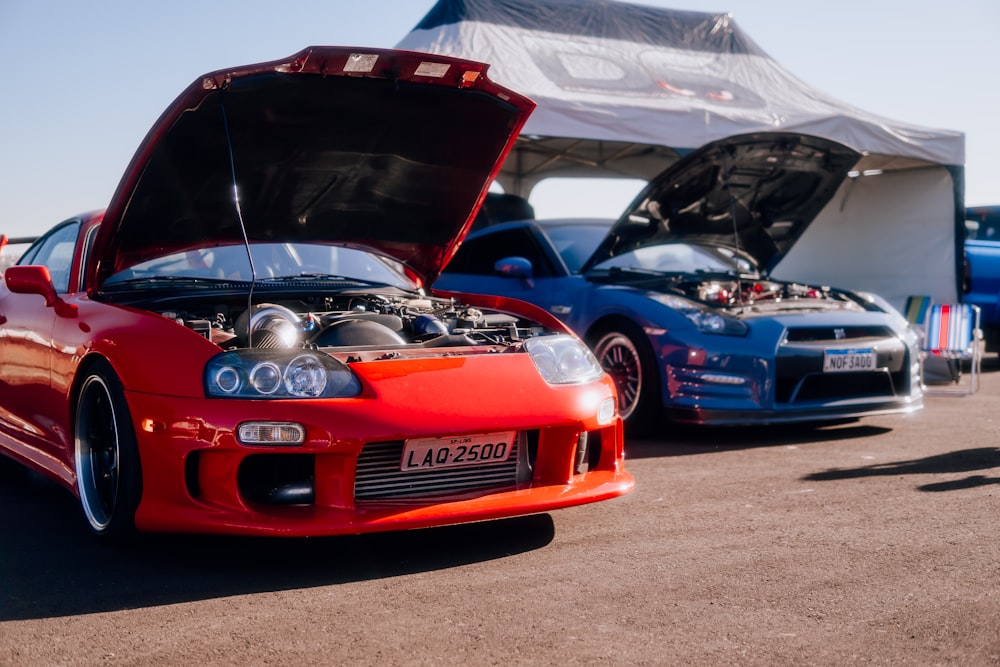 a red sports car parked next to a blue sports car