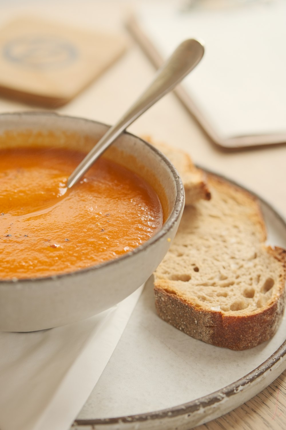 eine Schüssel Suppe und ein Stück Brot auf einem Teller