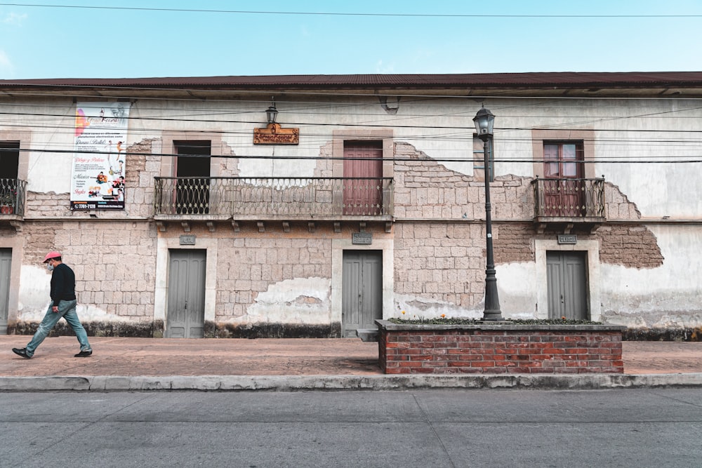 a man walking down the street in front of a building