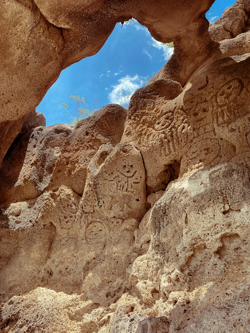 a rock formation with carvings on it and a sky background