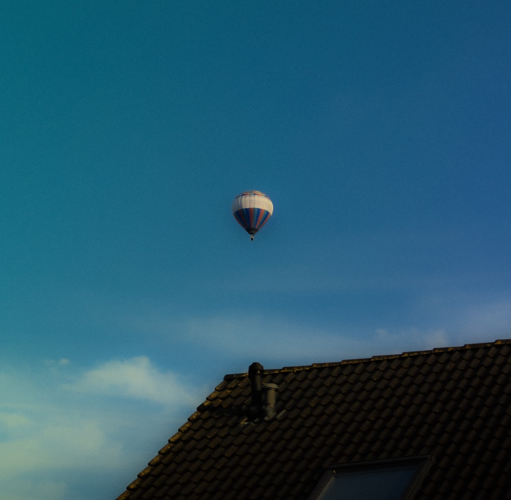a hot air balloon flying over a roof