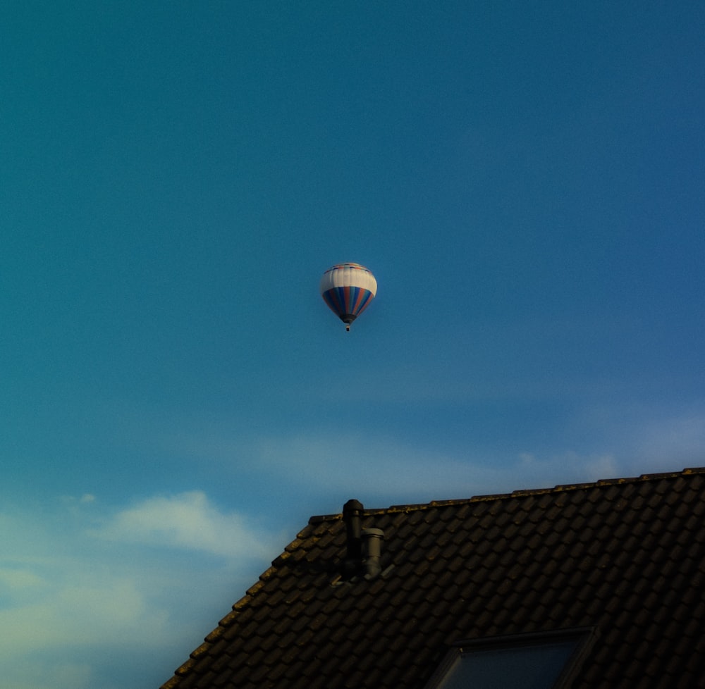 una mongolfiera che vola sopra un tetto