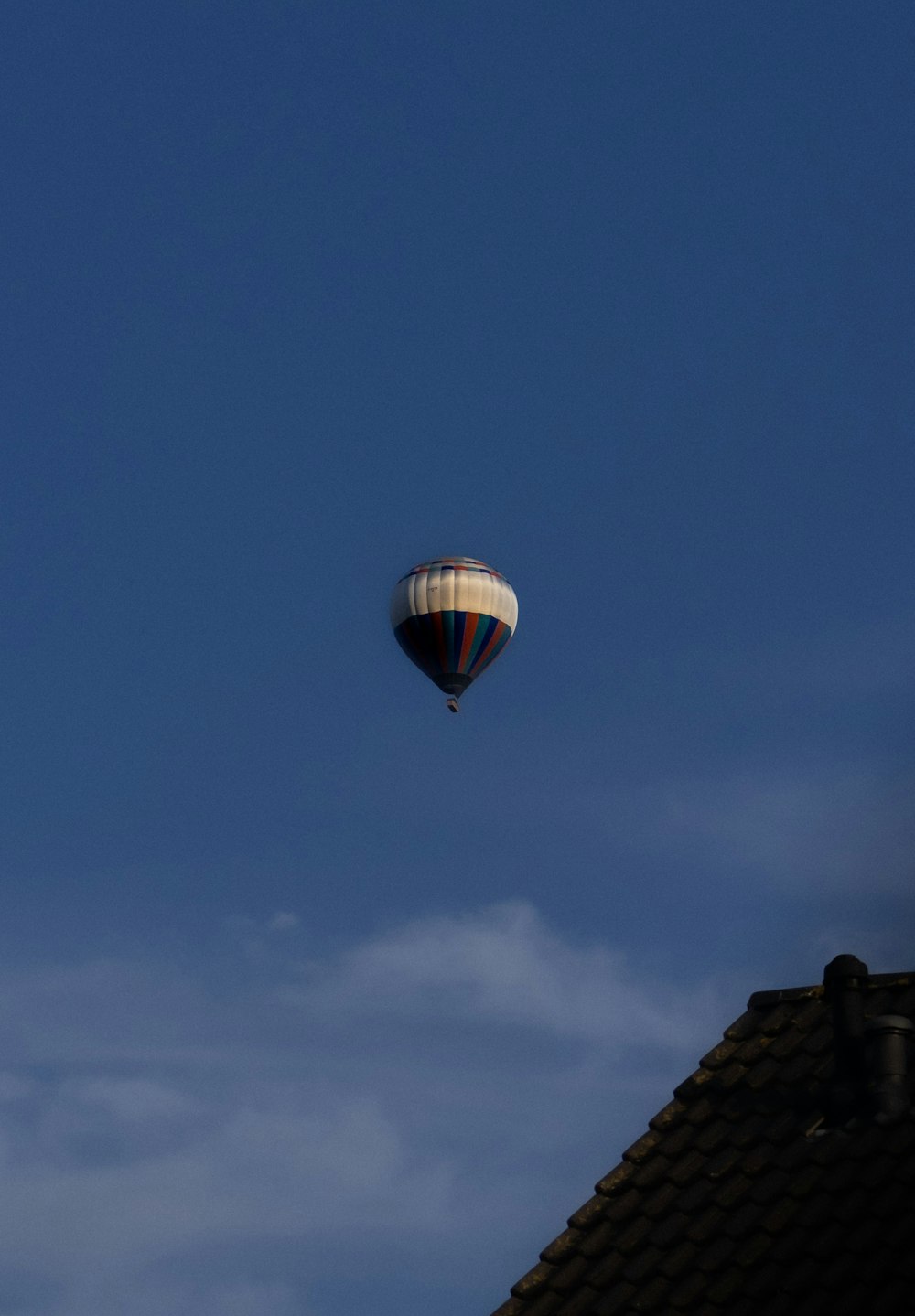 a hot air balloon flying over a house