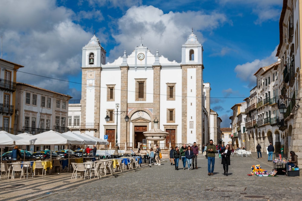 a group of people walking down a cobblestone street