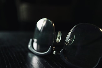 Close-up of golden eyeglass frames resting on a velvet surface with soft lighting.