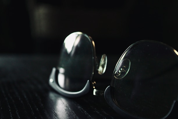 Close-up of golden eyeglass frames resting on a velvet surface with soft lighting.