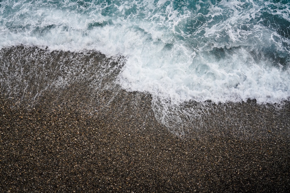 an aerial view of a beach with waves crashing on it