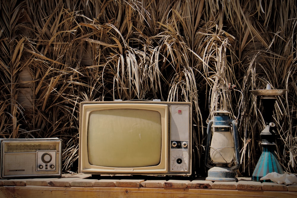 an old tv sitting on top of a wooden shelf