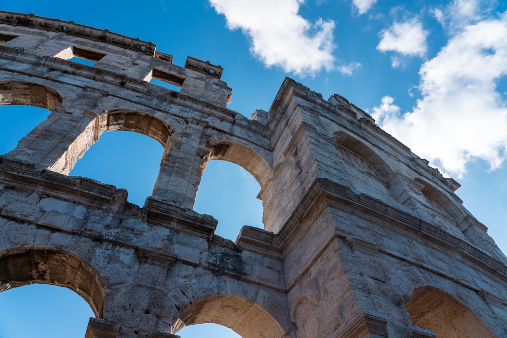 a large stone structure with arched windows under a blue sky