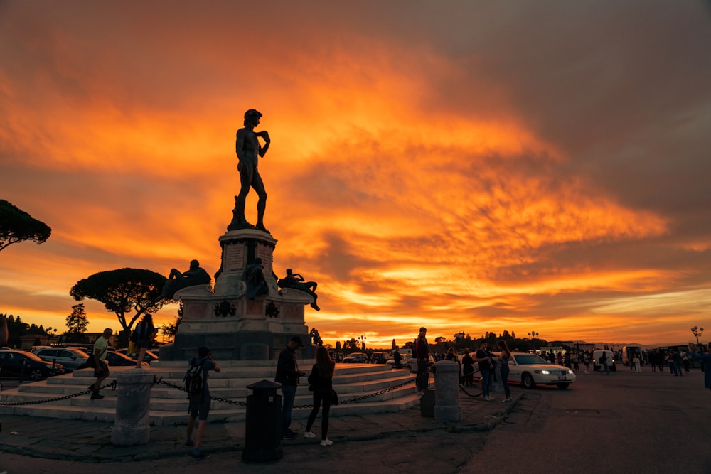 a group of people standing around a statue