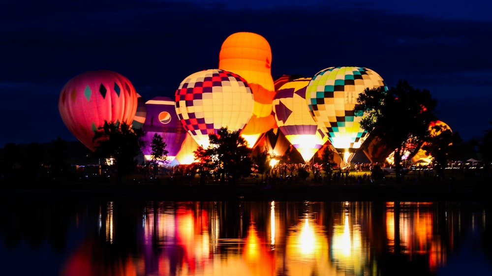 a group of hot air balloons floating over a lake