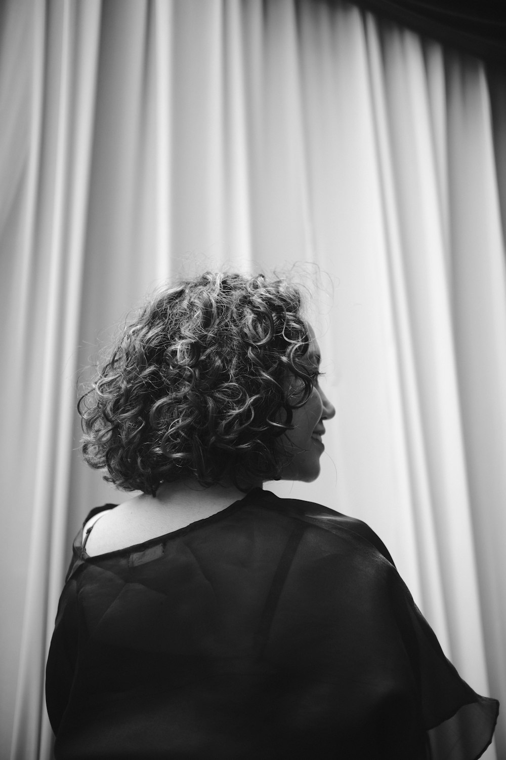 a black and white photo of a woman with curly hair