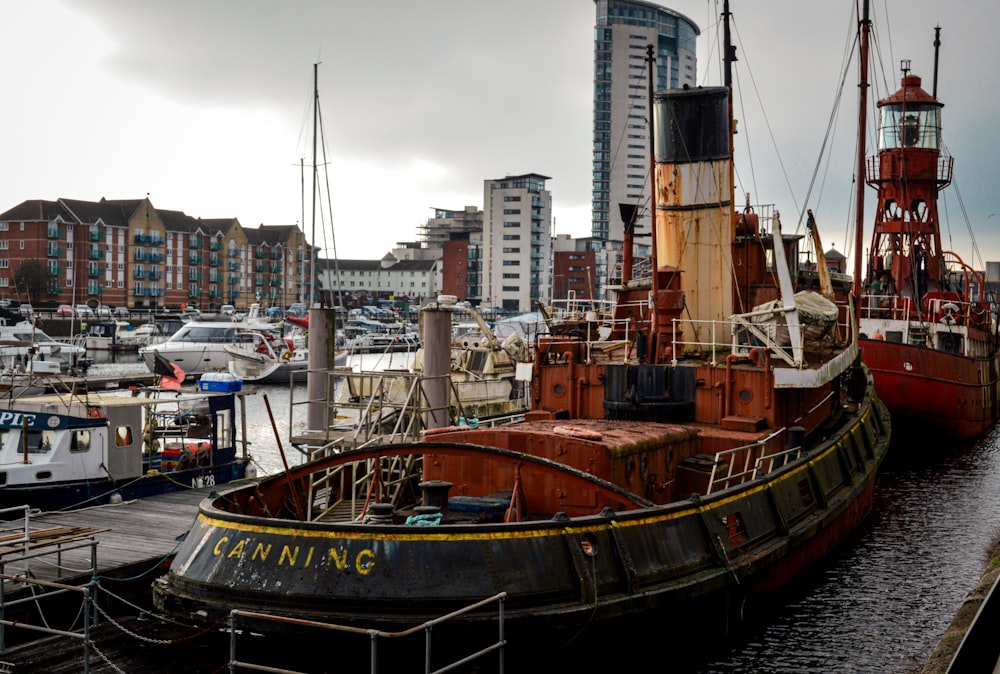 a large boat sitting in a harbor next to a tall building