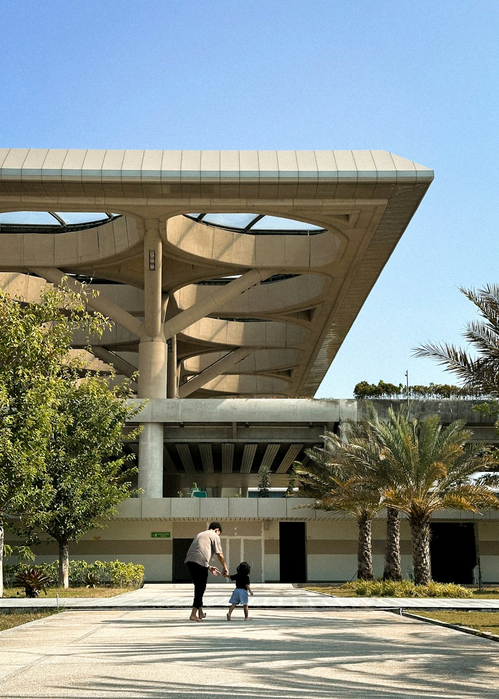 a man and a child walking in front of a building