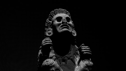 Abstract stone sculpture with gold accents reflecting Andean mountain shapes.