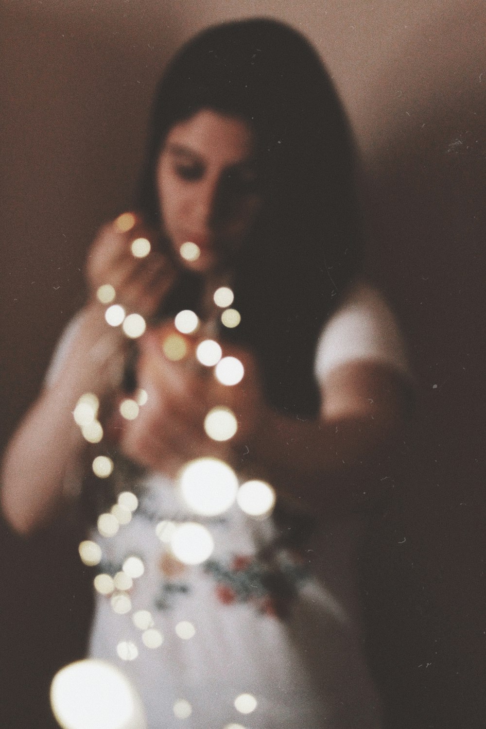 a woman holding a string of lights in her hands