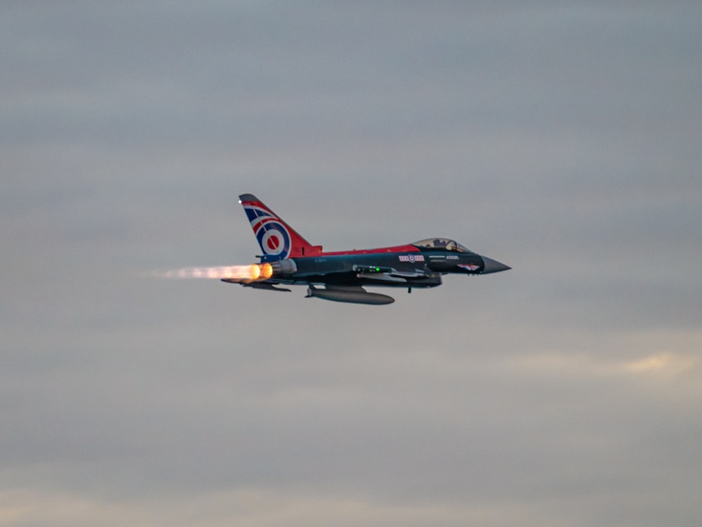 a fighter jet flying through a cloudy sky