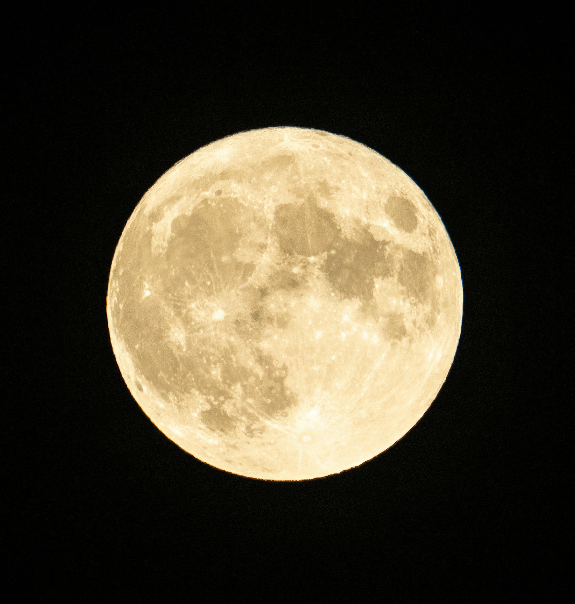 a full moon is seen in the dark sky