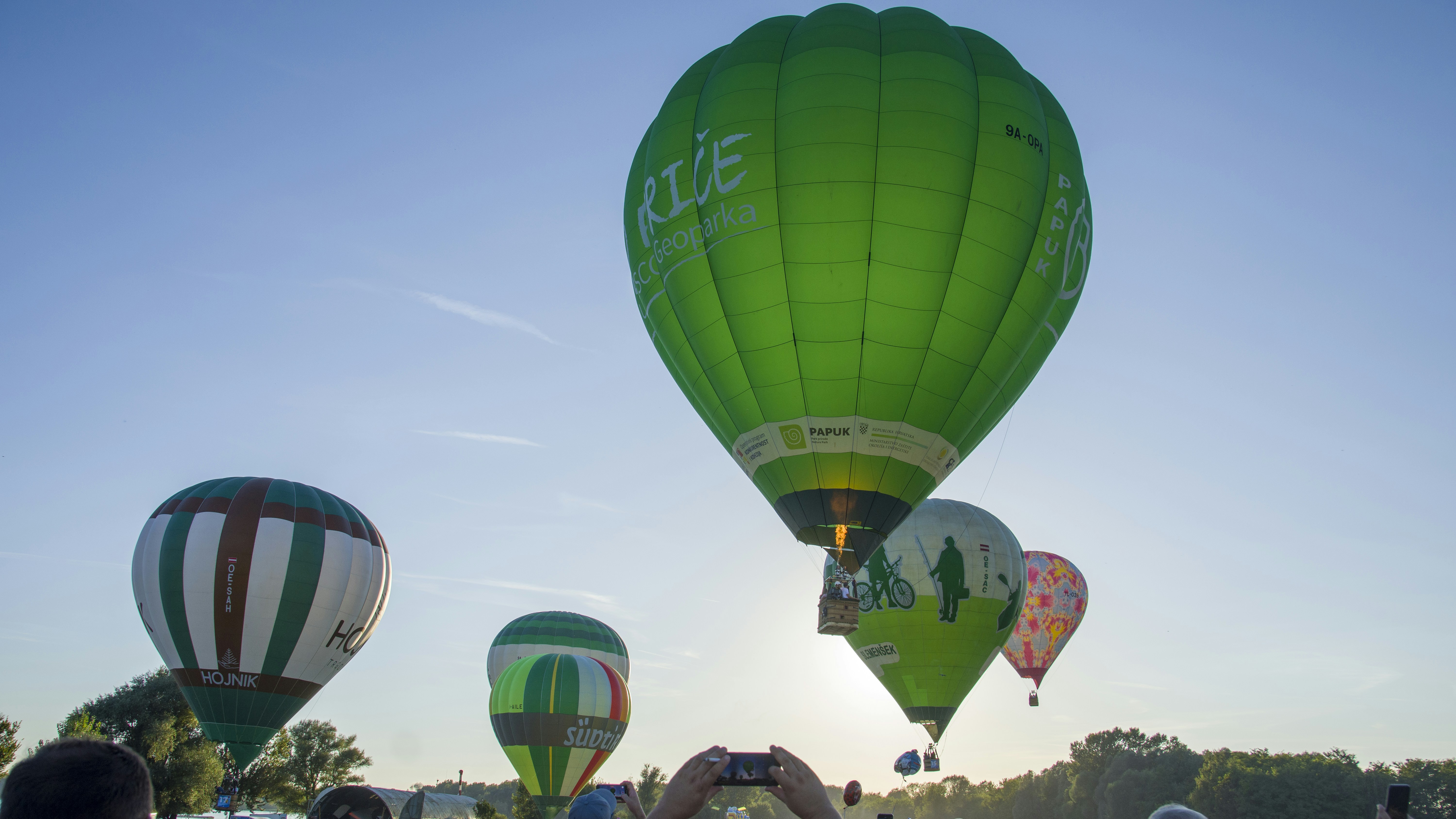 Ein Haufen Heißluftballons, die am Himmel fliegen