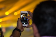 Close-up of a social media influencer capturing content with a smartphone in a stylish urban setting.