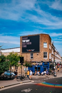 a group of people walking across a street next to a tall building