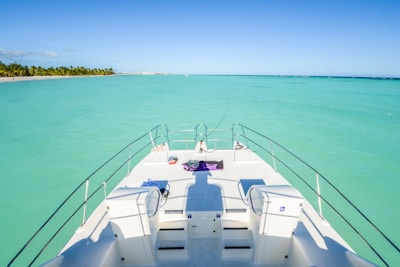 Close-up of a luxury yacht deck with sun loungers and blue ocean in the background.