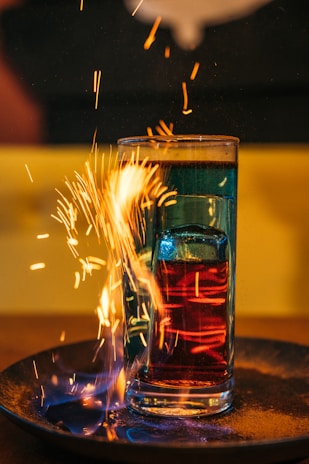 Colorful chemical reactions bubbling in glass beakers under bright lab lights.