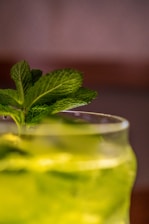 Elegant close-up of a glass filled with cannabis-infused rum with a subtle green leaf garnish.