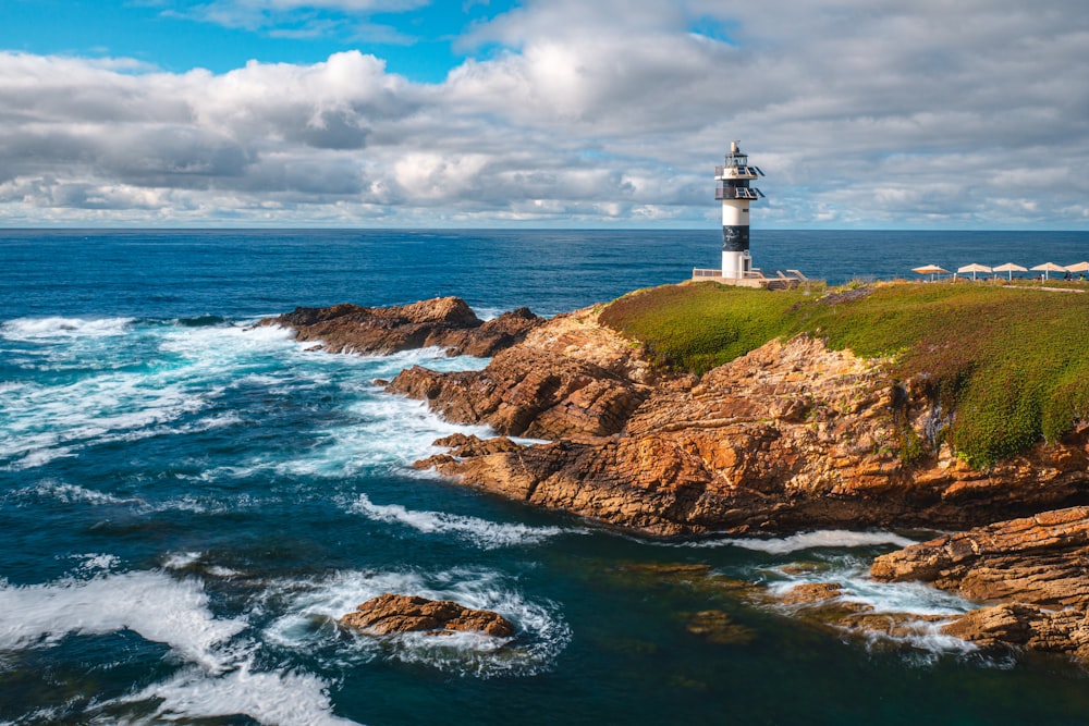 a light house sitting on top of a cliff next to the ocean