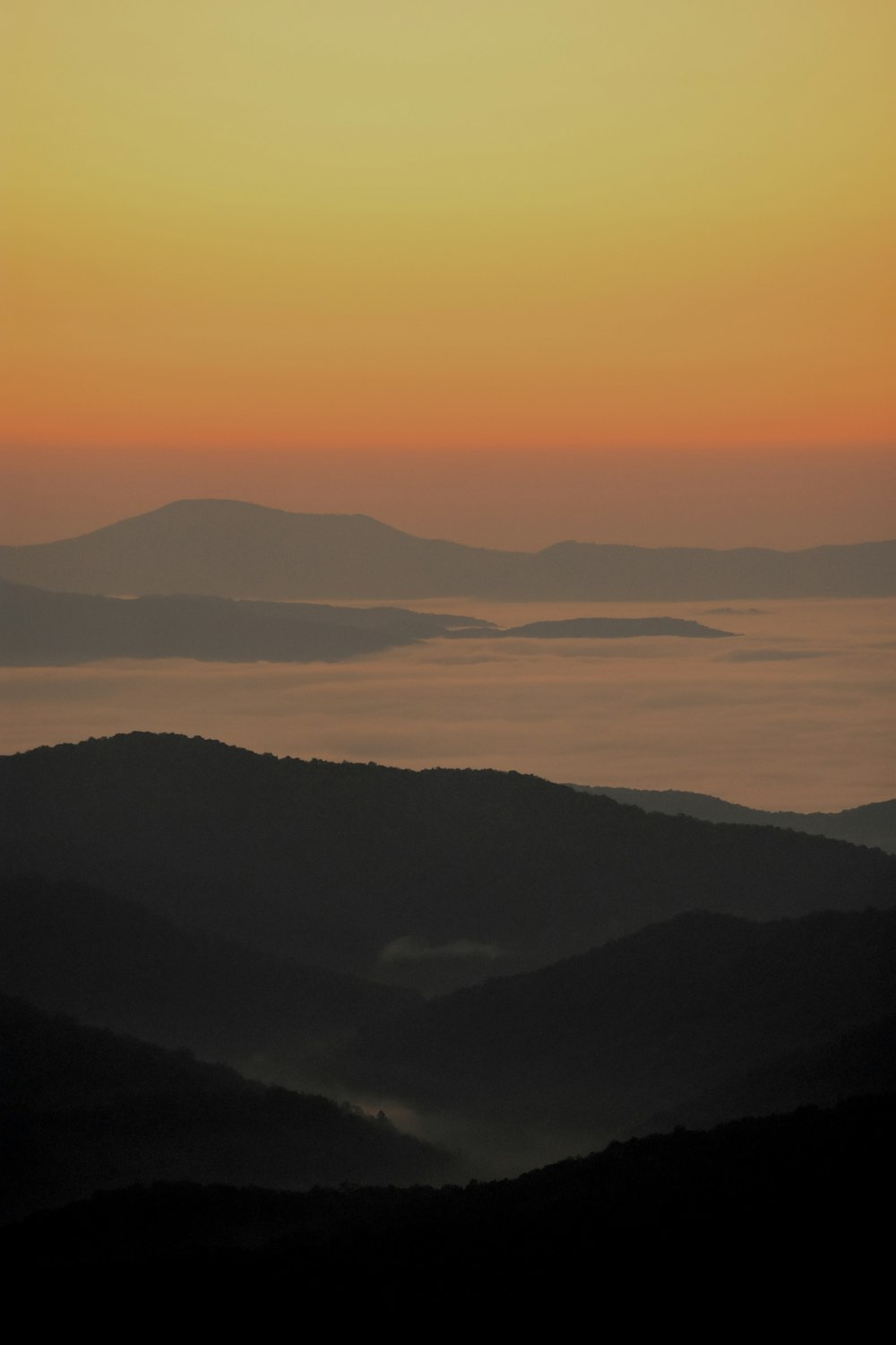 the sun is setting over a mountain range