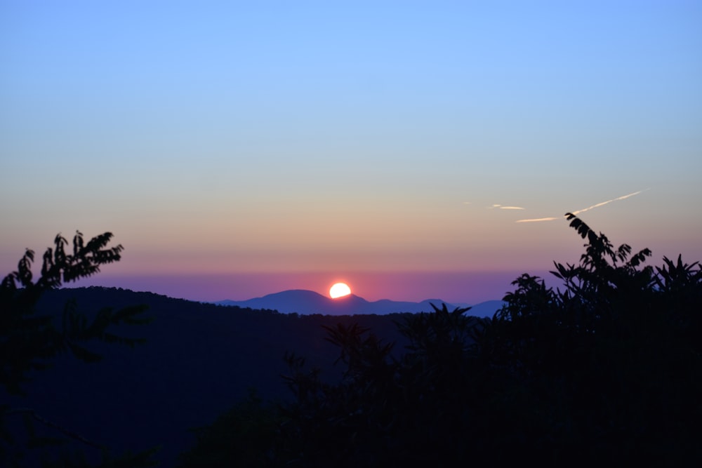 o sol está se pondo sobre uma cordilheira