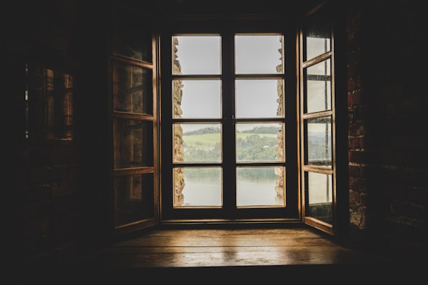 an open window with a view of a lake