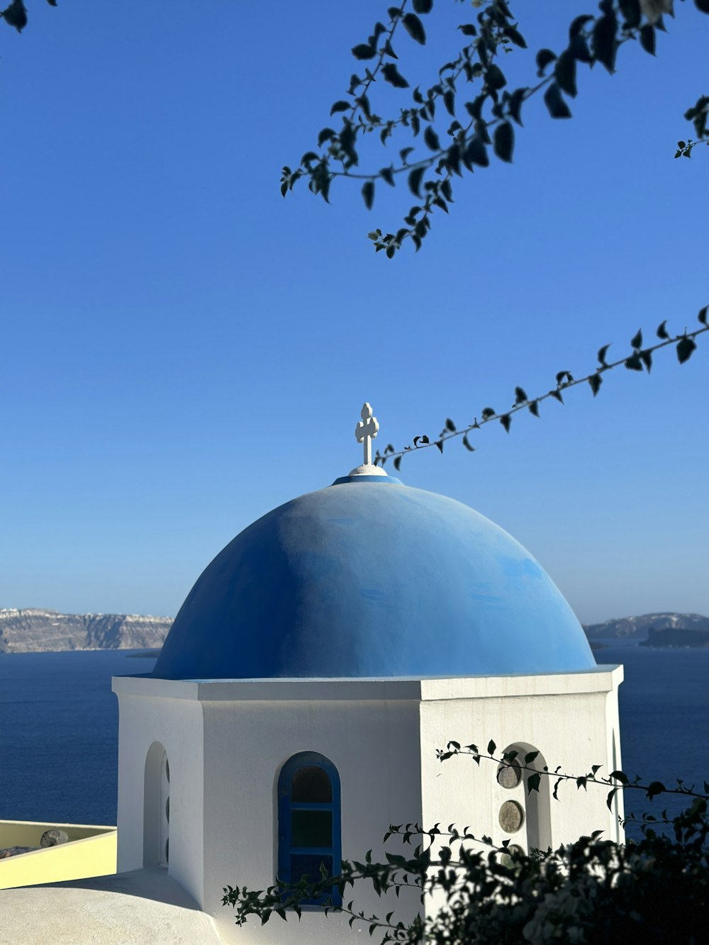 Un edificio blanco y azul con una cruz en la parte superior
