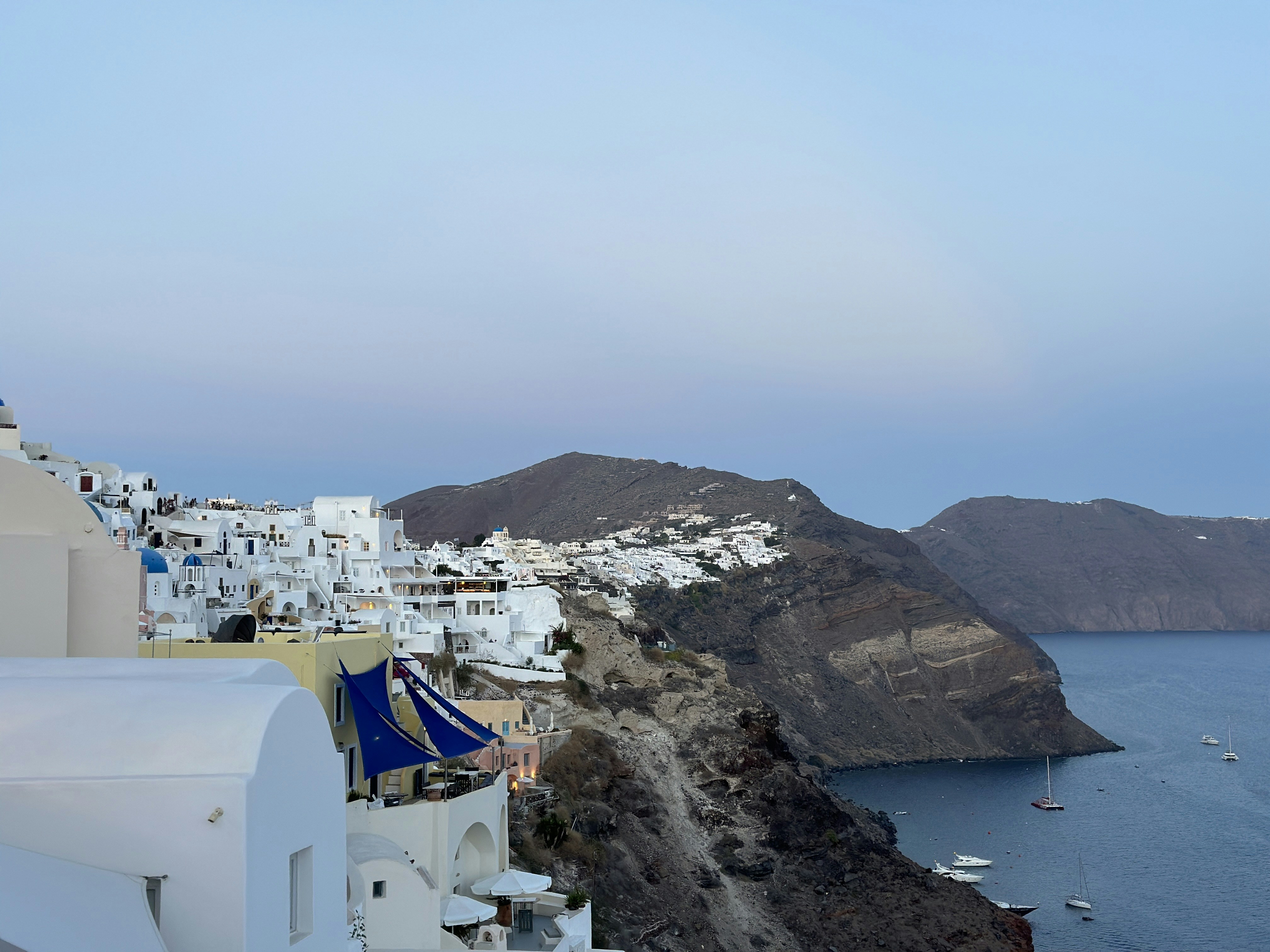 a view of a white village on a cliff overlooking the ocean