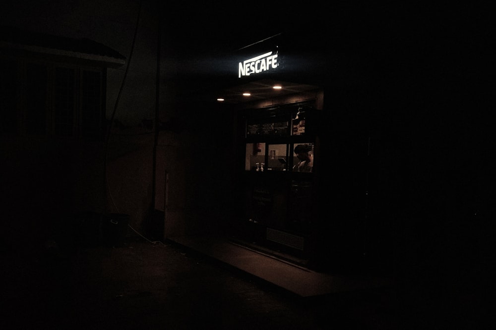 a dark room with a neon sign above the door