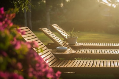 Foldable outdoor recliner set up on a sunny patio surrounded by greenery.
