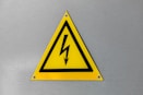 a yellow triangle sign with a lightning bolt on it