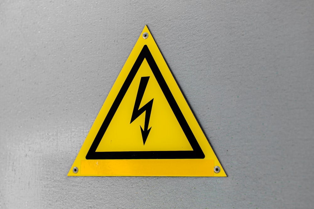 a yellow triangle sign with a lightning bolt on it