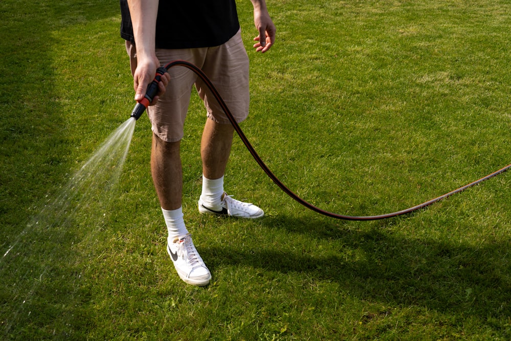 a man is spraying water on the grass