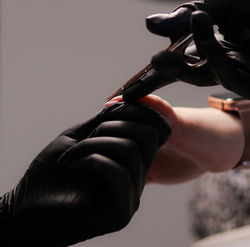 a person cutting another persons hair with a pair of scissors