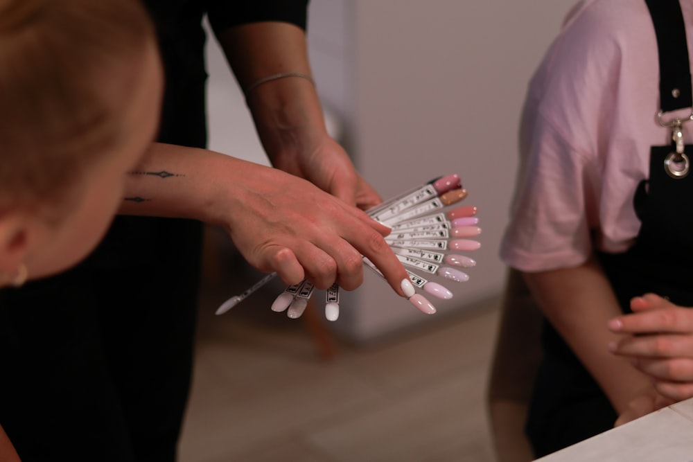 a woman holding a bunch of nails in her hands