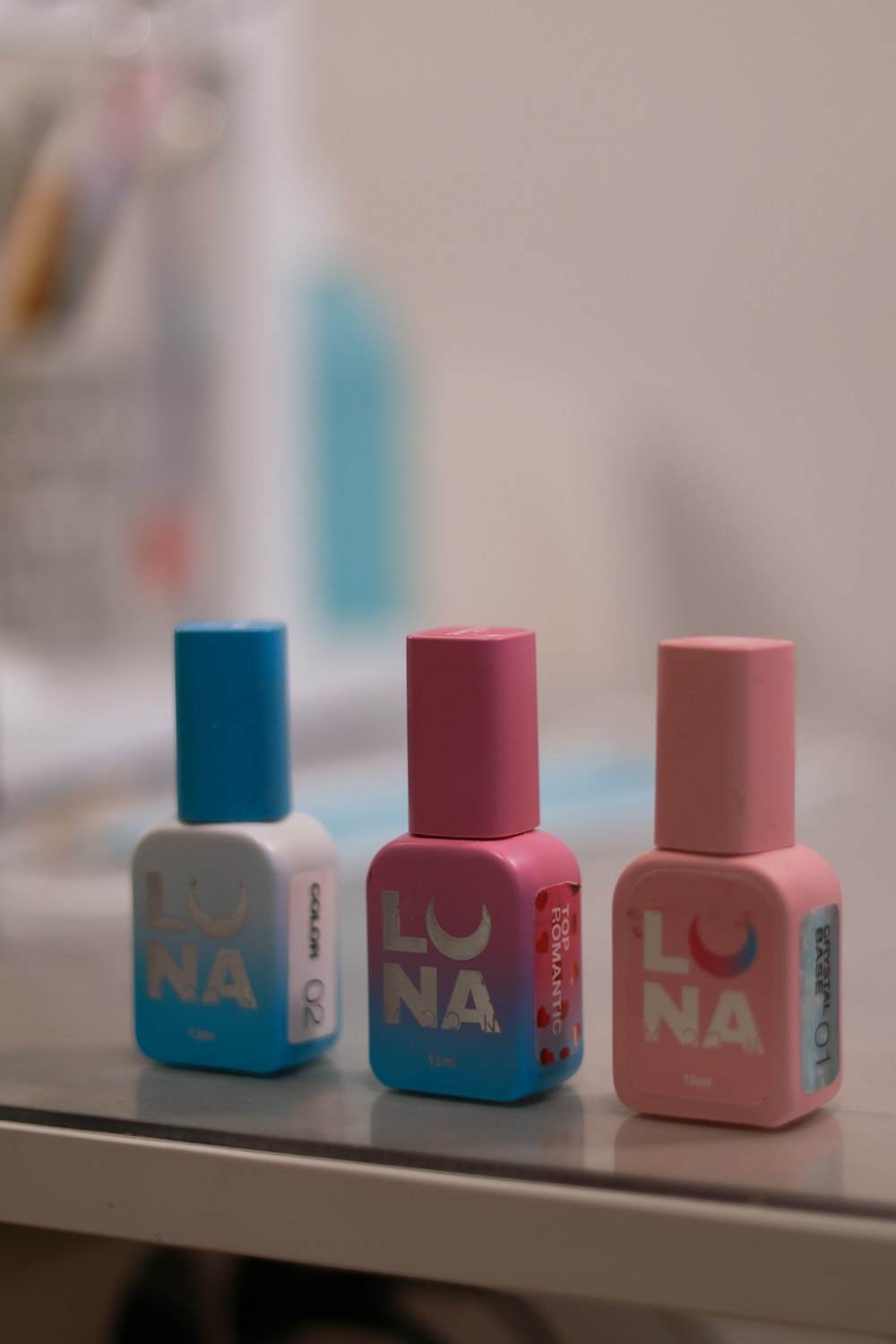 three bottles of nail polish sitting on a table
